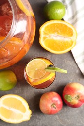 Photo of Punch and fresh fruits on grey table, flat lay. Refreshing drink