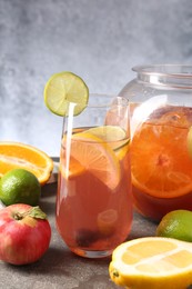 Photo of Punch and fresh fruits on grey table. Refreshing drink