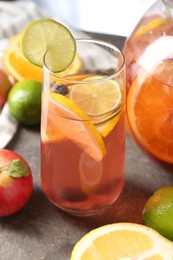 Photo of Punch and fresh fruits on grey table, closeup. Refreshing drink