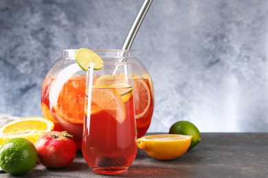 Photo of Punch and fresh fruits on grey table, space for text. Refreshing drink