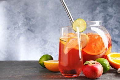 Photo of Punch and fresh fruits on grey table, space for text. Refreshing drink