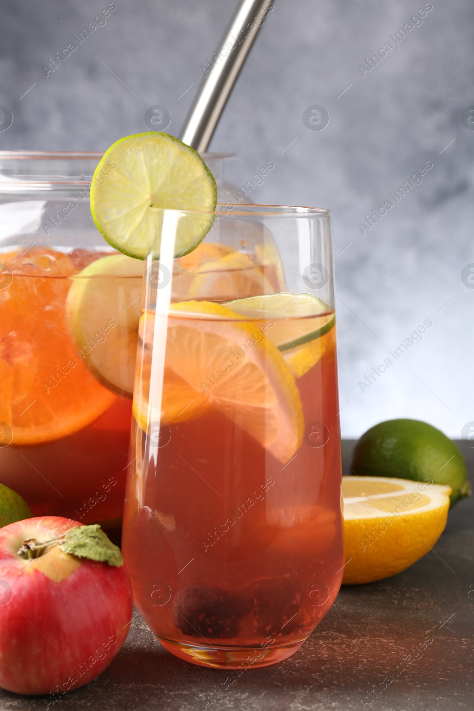 Punch and fresh fruits on grey table, closeup. Refreshing drink Photo of Punch and fresh fruits on grey table, closeup. Refreshing drink
