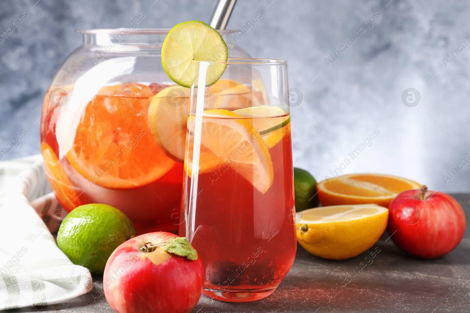 Punch and fresh fruits on grey table, closeup. Refreshing drink Photo of Punch and fresh fruits on grey table, closeup. Refreshing drink