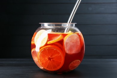 Photo of Fruity punch on black wooden table. Refreshing drink