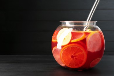 Photo of Fruity punch on black wooden table, space for text. Refreshing drink