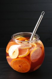 Photo of Fruity punch on black wooden table. Refreshing drink
