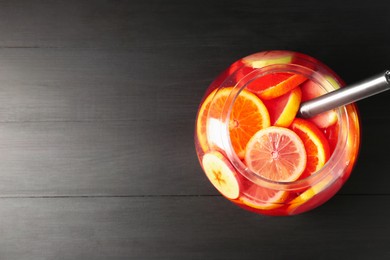 Photo of Fruity punch on black wooden table, top view with space for text. Refreshing drink