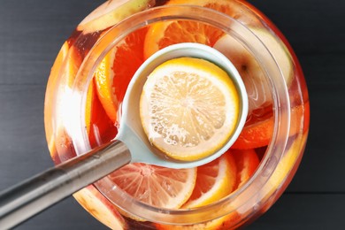 Photo of Fruity punch on black wooden table, top view. Refreshing drink