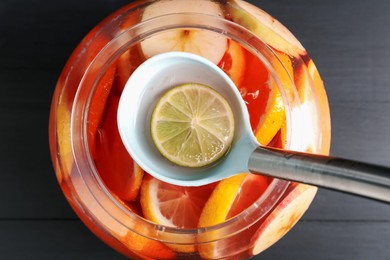 Photo of Fruity punch on black wooden table, top view. Refreshing drink
