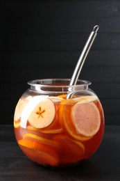 Photo of Fruity punch on black wooden table. Refreshing drink
