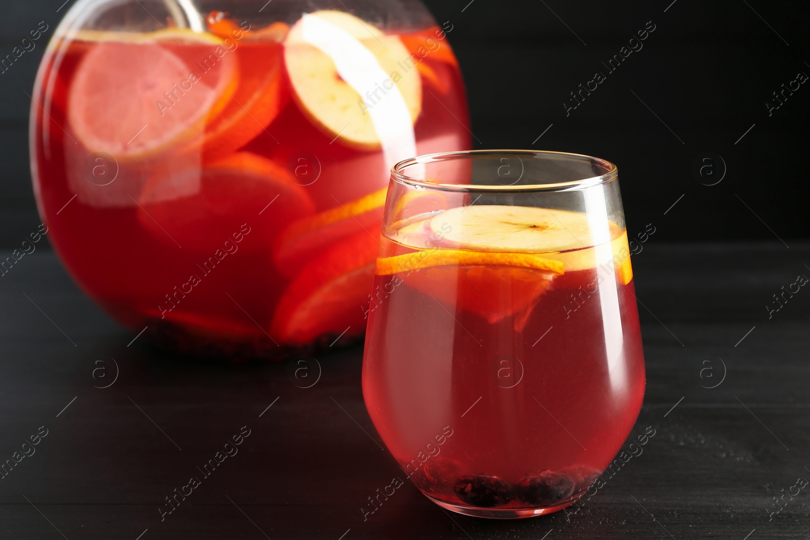 Fruity punch on black wooden table, closeup. Refreshing drink Photo of Fruity punch on black wooden table, closeup. Refreshing drink