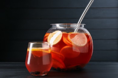 Photo of Fruity punch on black wooden table. Refreshing drink