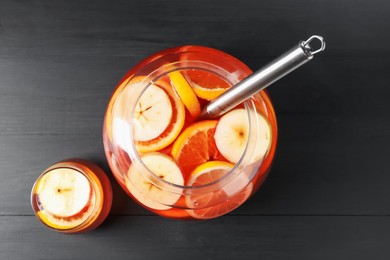 Photo of Fruity punch on black wooden table, flat lay. Refreshing drink
