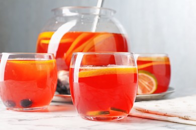 Photo of Fruity punch on white marble table, closeup. Refreshing drink