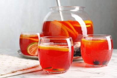 Photo of Fruity punch on white marble table, closeup. Refreshing drink