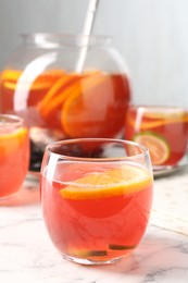Photo of Fruity punch on white marble table, closeup. Refreshing drink