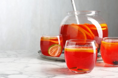 Photo of Fruity punch on white marble table, space for text. Refreshing drink