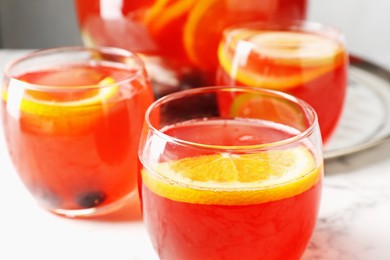 Photo of Fruity punch on white marble table, closeup. Refreshing drink