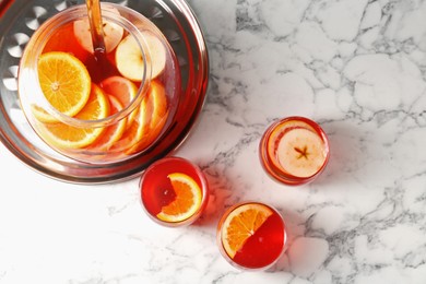 Photo of Fruity punch on white marble table, flat lay. Refreshing drink