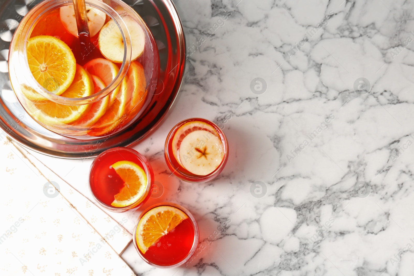 Photo of Fruity punch on white marble table, flat lay with space for text. Refreshing drink