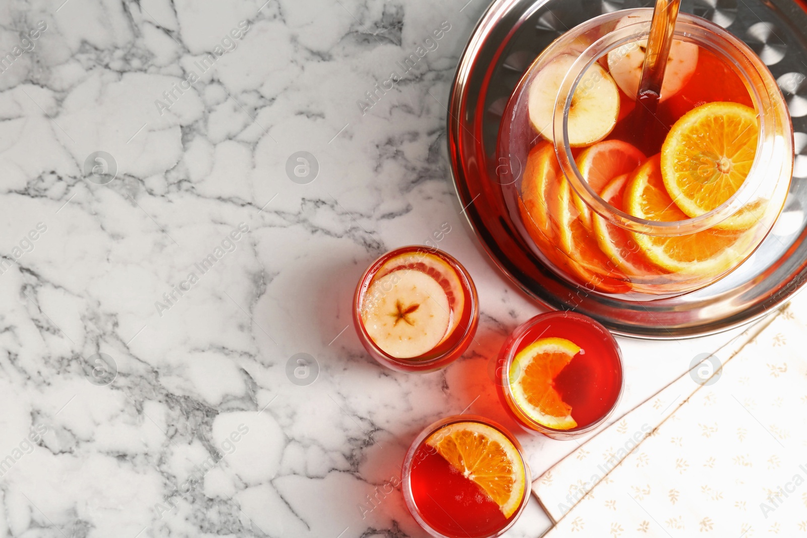 Photo of Fruity punch on white marble table, flat lay with space for text. Refreshing drink