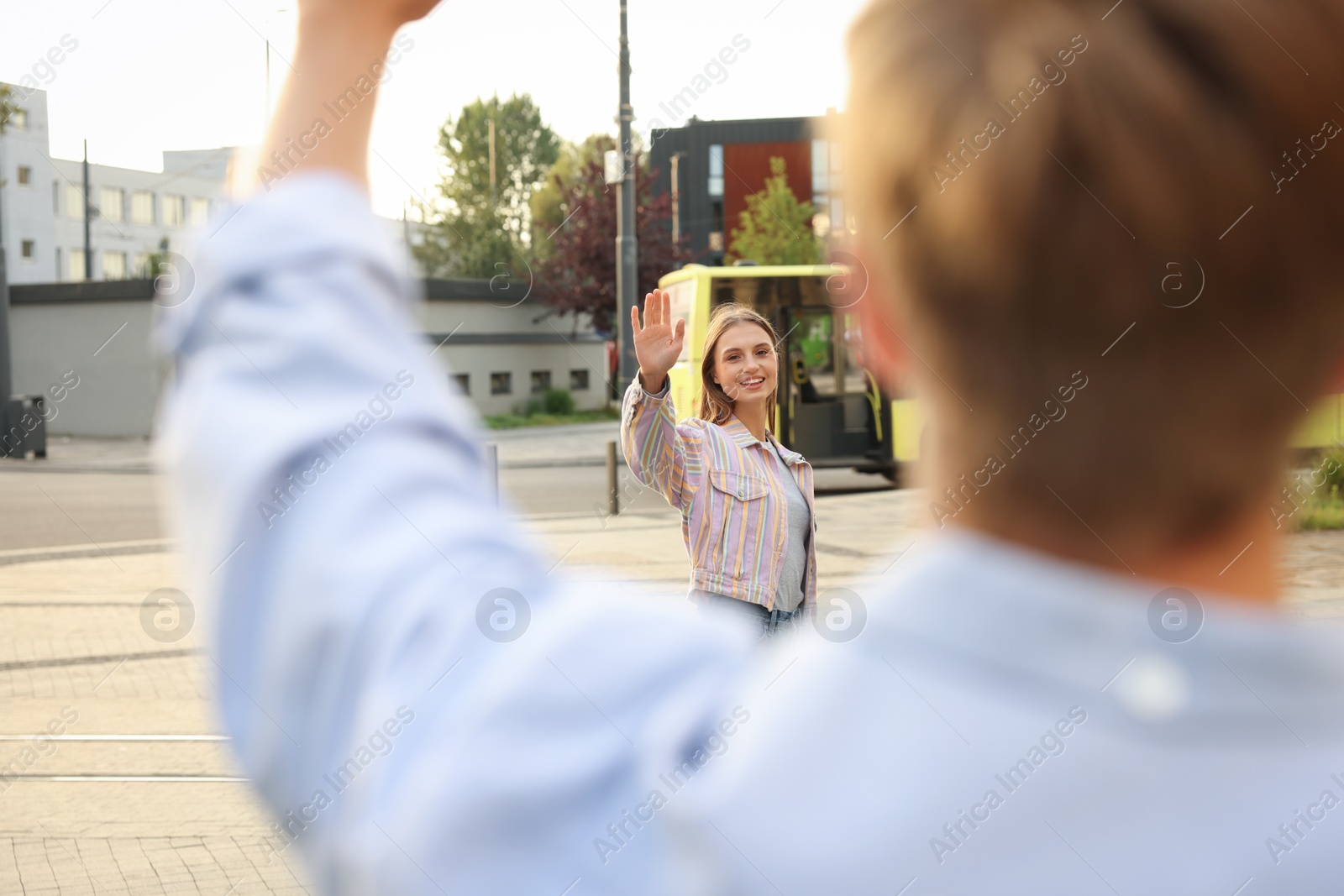 Photo of Goodbye. Woman waving to her boyfriend outdoors, selective focus