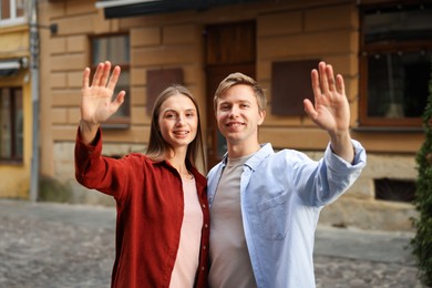 Photo of Goodbye. Lovely couple waving on city street