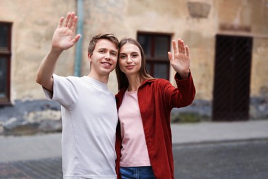 Photo of Goodbye. Lovely couple waving on city street