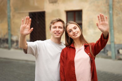 Photo of Goodbye. Lovely couple waving on city street