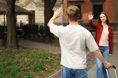 Photo of Goodbye. Man waving to his girlfriend outdoors, selective focus. Space for text