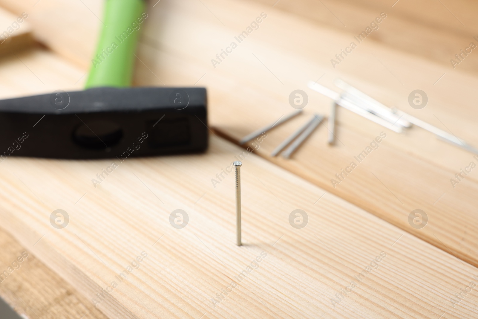 Metal nails, wooden planks and hammer on table, closeup Photo of Metal nails, wooden planks and hammer on table, closeup