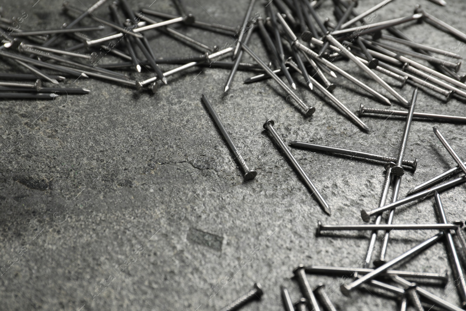 Many metal nails on grey table, closeup. Space for text Photo of Many metal nails on grey table, closeup. Space for text