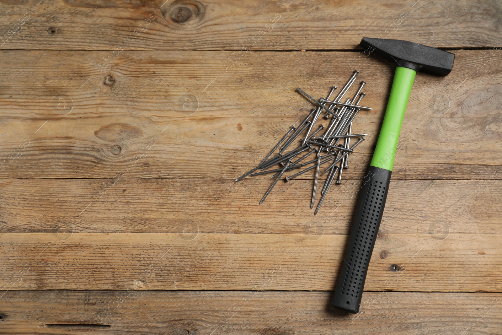 Hammer and metal nails on wooden table, flat lay. Space for text Photo of Hammer and metal nails on wooden table, flat lay. Space for text