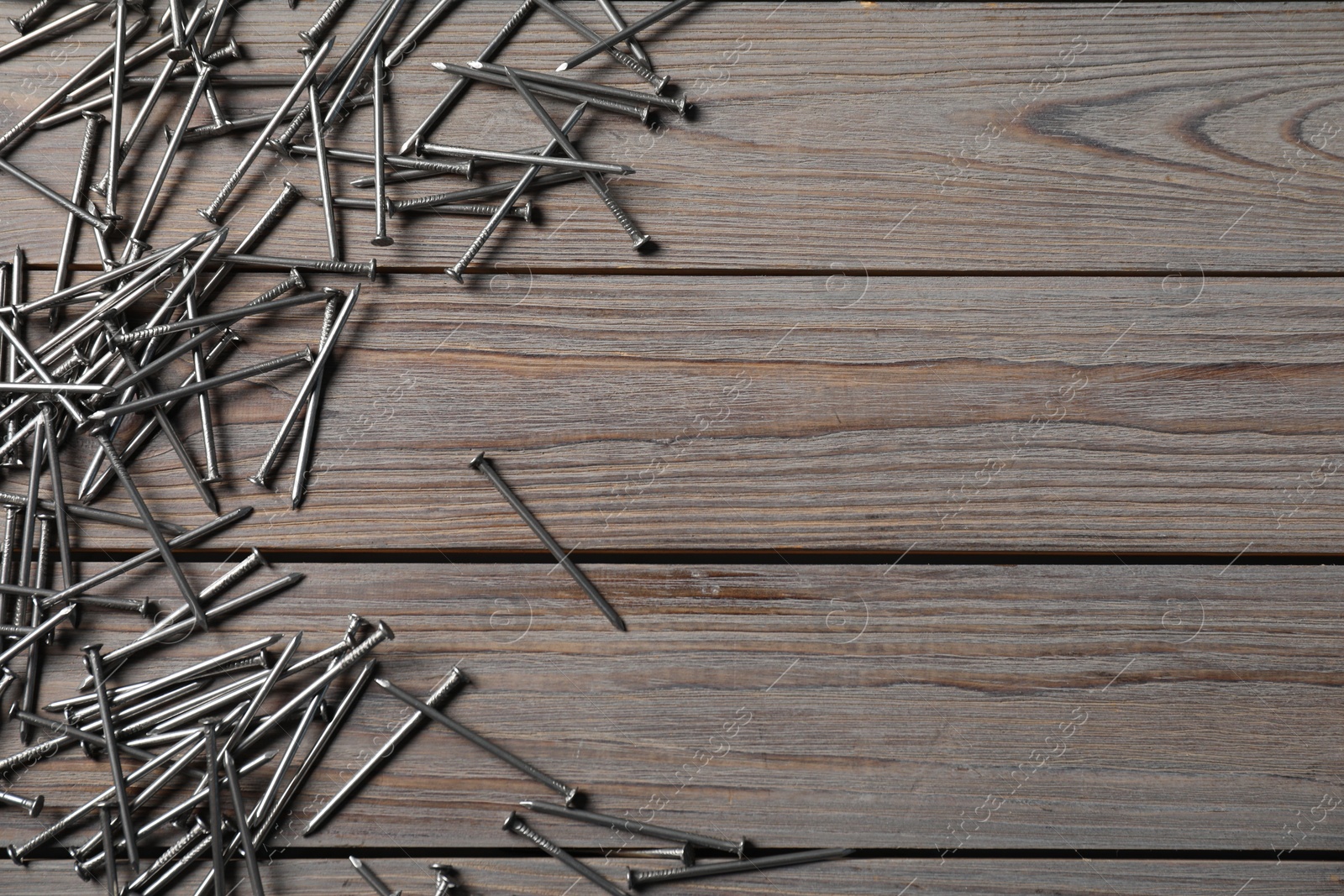 Many metal nails on wooden table, flat lay. Space for text Photo of Many metal nails on wooden table, flat lay. Space for text