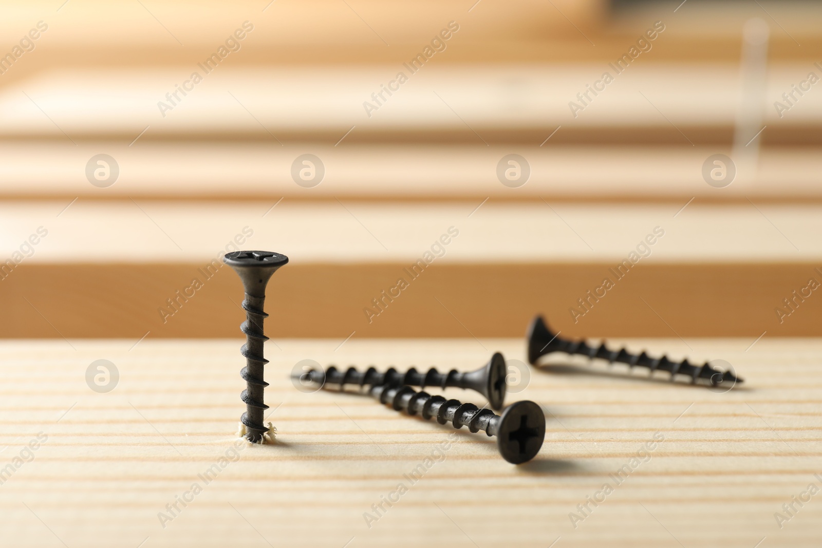 Metal screws and wooden plank on table, closeup Photo of Metal screws and wooden plank on table, closeup