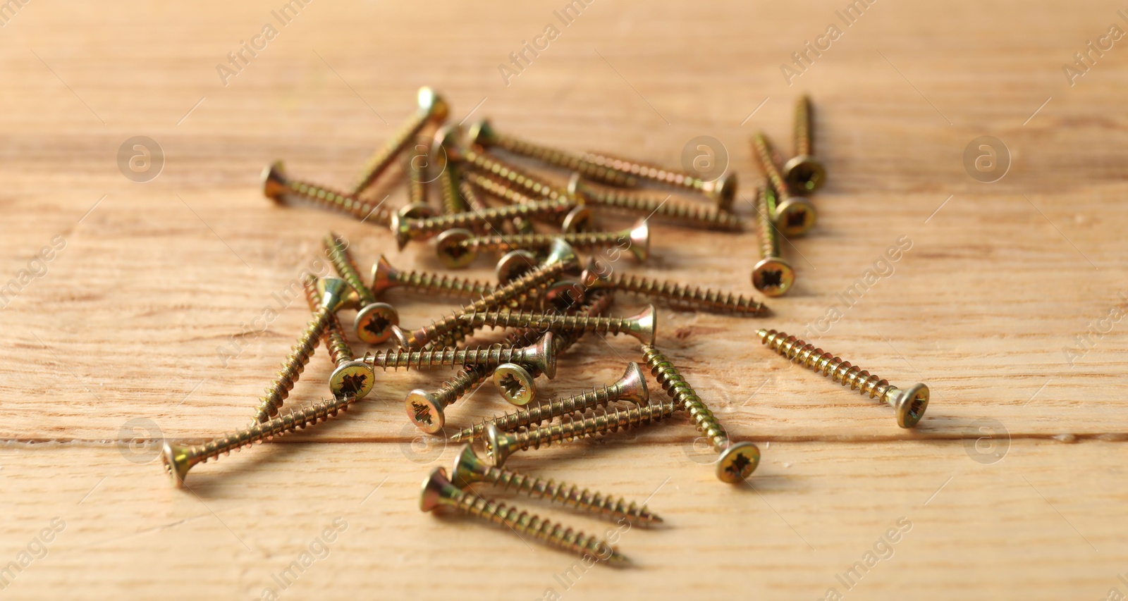 Many metal screws on wooden table, closeup Photo of Many metal screws on wooden table, closeup
