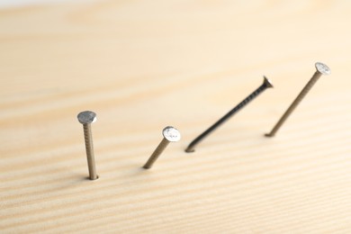 Photo of Many metal nails in wooden plank, closeup