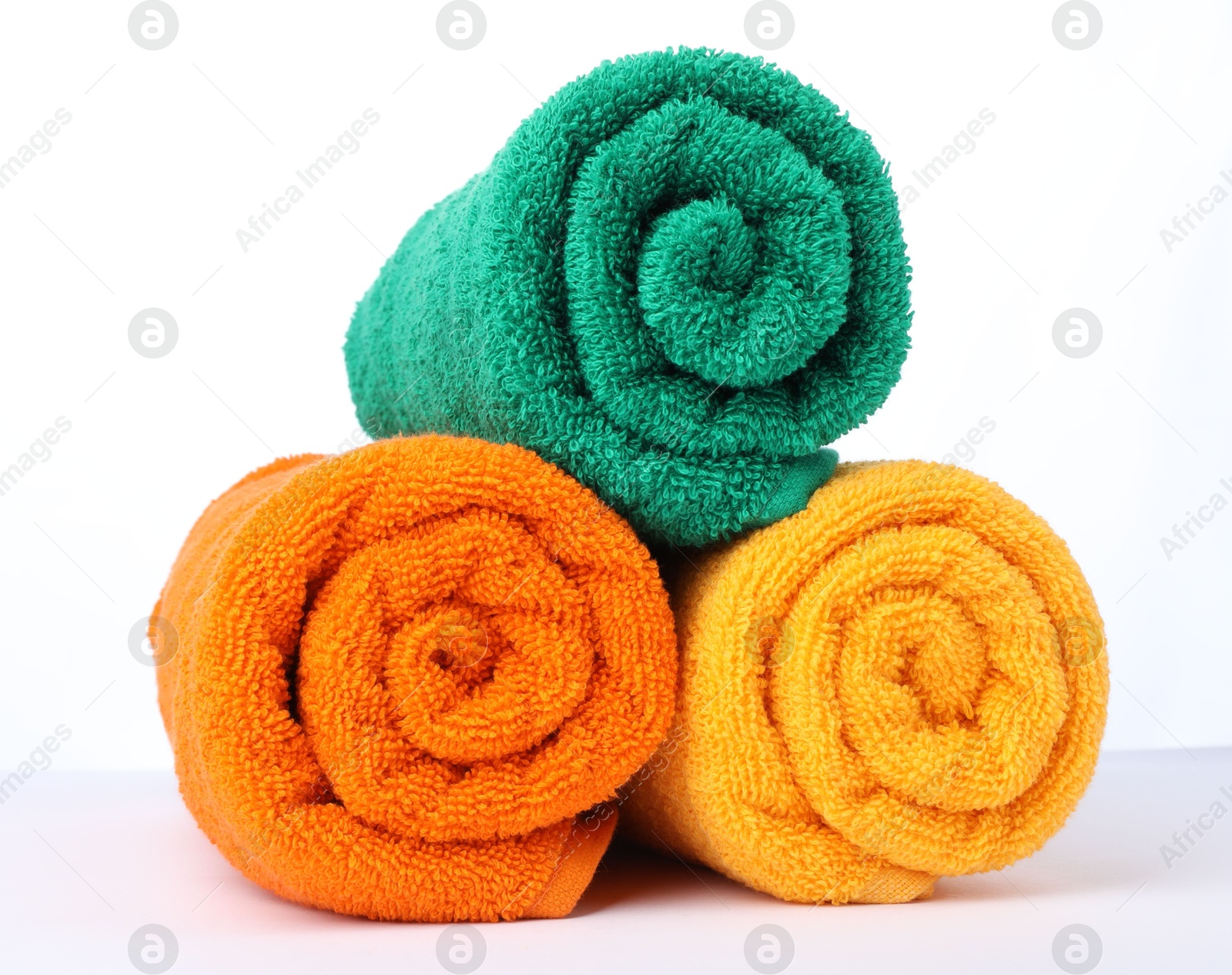 Photo of Colorful rolled terry towels isolated on white