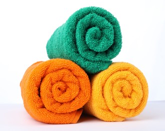 Photo of Colorful rolled terry towels isolated on white