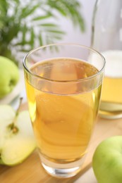 Photo of Fresh cider in glass, bottle and apples on table, closeup