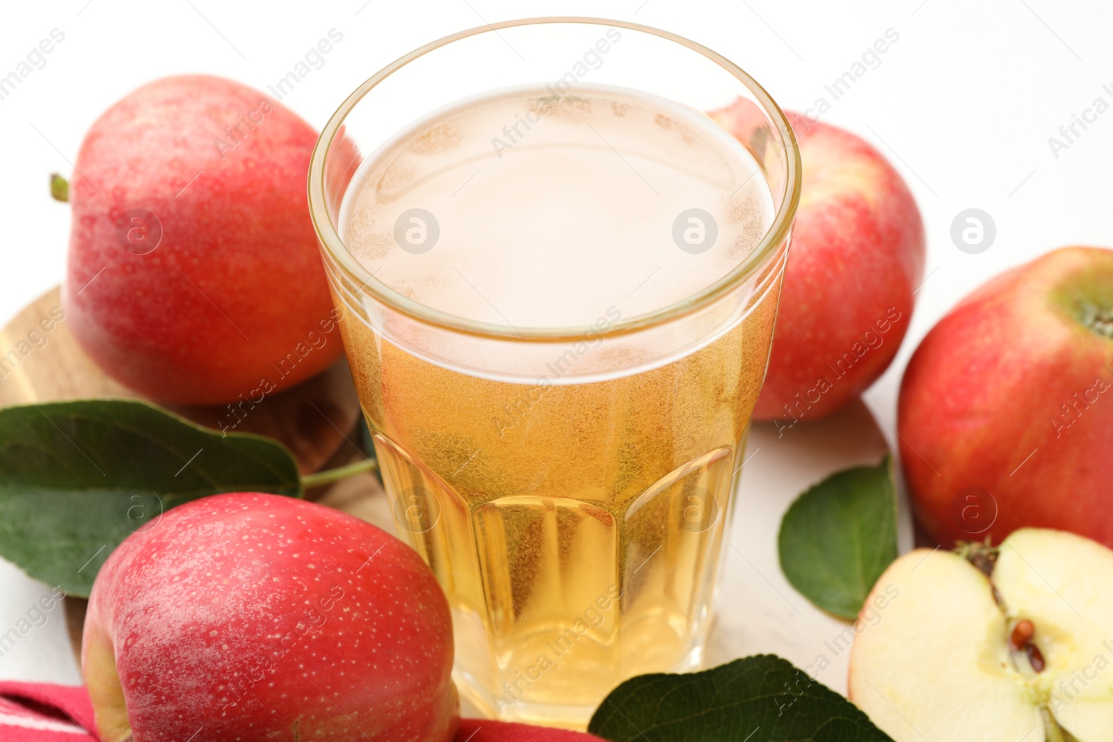 Fresh cider in glass and apples on white table, closeup Photo of Fresh cider in glass and apples on white table, closeup