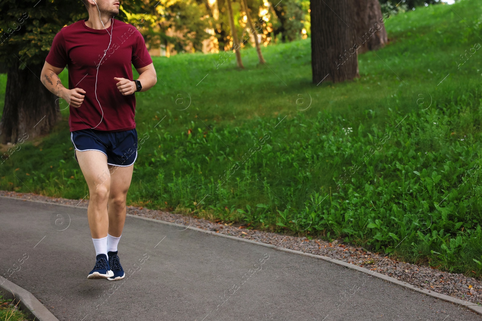 Athletic young man in sportswear running outdoors, closeup. Space for text Photo of Athletic young man in sportswear running outdoors, closeup. Space for text