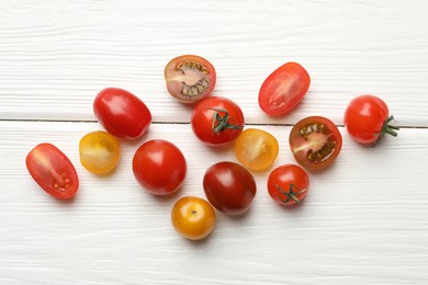 Photo of Different ripe tomatoes on white wooden table, flat lay