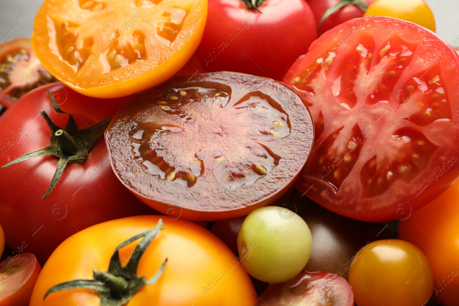 Photo of Many different ripe tomatoes on table, closeup