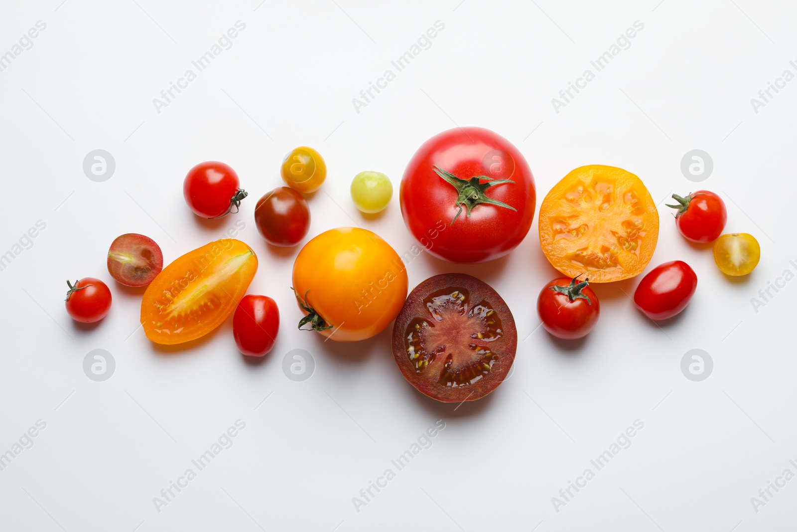 Photo of Different ripe tomatoes on white table, flat lay