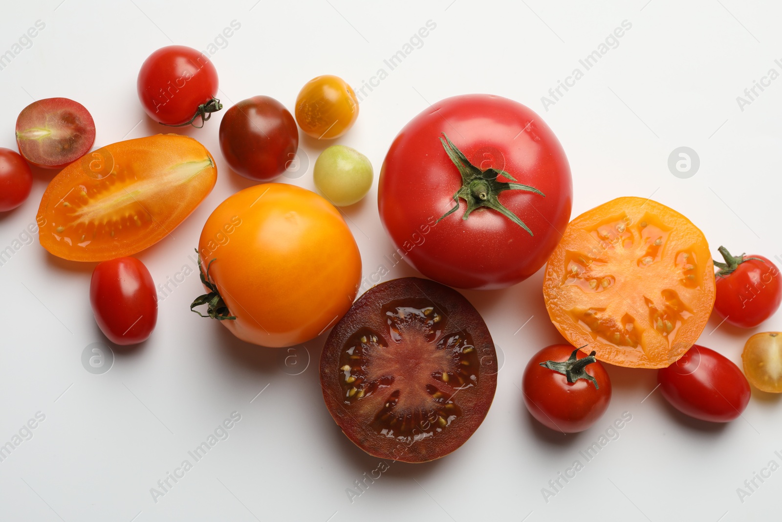 Photo of Different ripe tomatoes on white table, flat lay