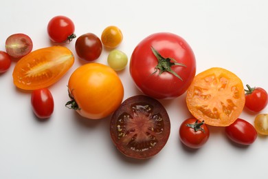 Photo of Different ripe tomatoes on white table, flat lay