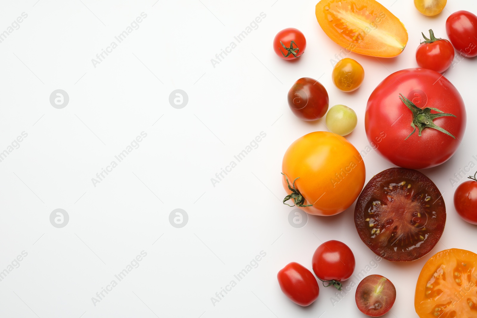 Photo of Different ripe tomatoes on white table, flat lay. Space for text