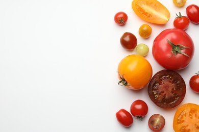 Photo of Different ripe tomatoes on white table, flat lay. Space for text