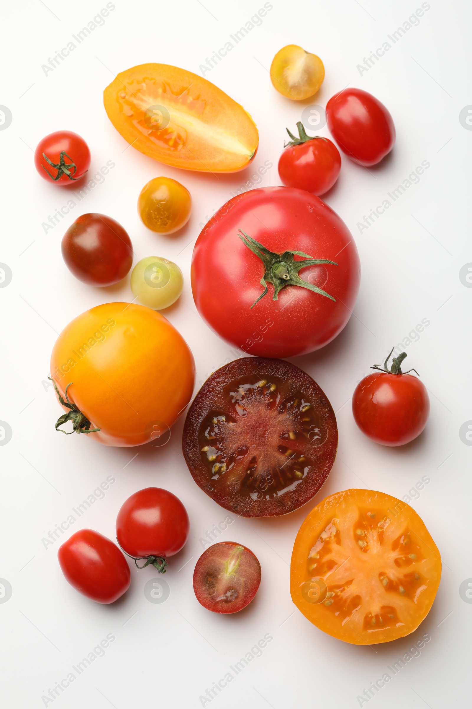 Photo of Different ripe tomatoes on white table, flat lay